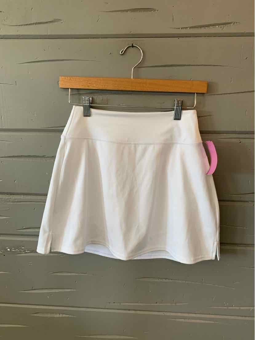 White athletic skirt with wide waistband and slightly flared hem, hanging on wooden hanger.