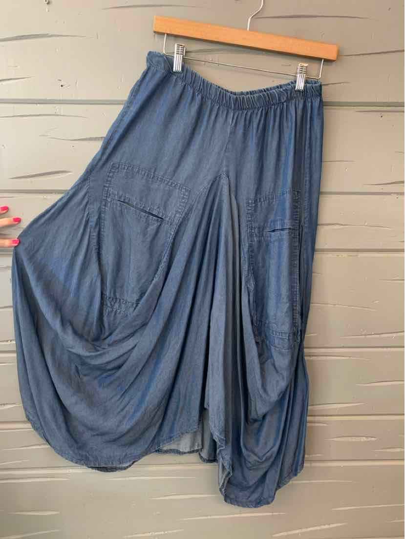 Blue loose-fitting midi skirt with elastic waistband and two large front patch pockets.