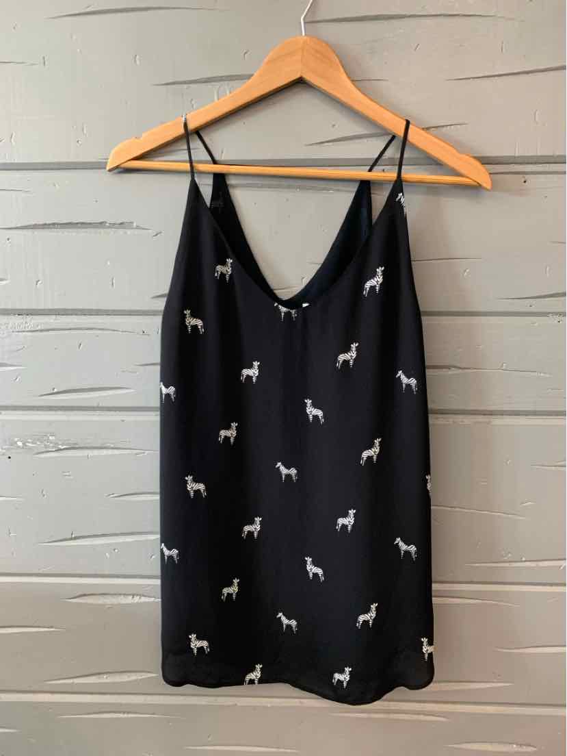 Black sleeveless dress with white zebra print and thin adjustable straps on wooden hanger.