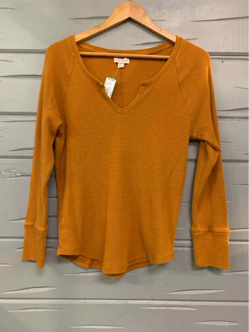 Long-sleeve mustard yellow V-neck knit top with ribbed cuffs and hem on wooden hanger.