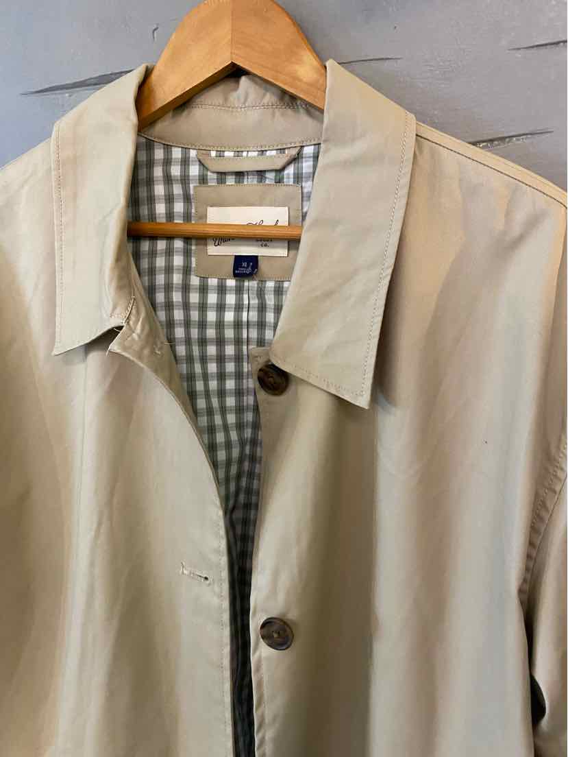 Tan lightweight jacket with pointed collar and dark buttons, featuring a gingham pattern lining in white and light gray.