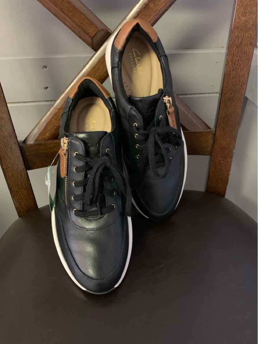 Black leather lace-up sneakers with zipper detail and white rubber soles, size 8.5.