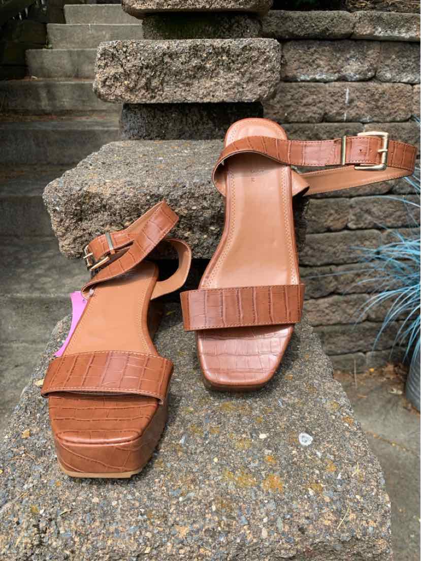 Brown leather block heel sandals with ankle straps and square toe design.