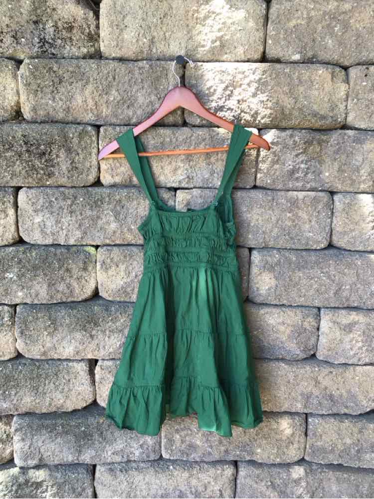 Green sleeveless sundress with wide straps, square neckline, and gathered skirt tiers.