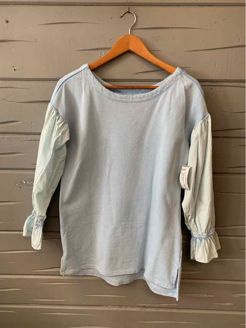 Light blue long-sleeve blouse with gathered ruffle cuffs and a boat neckline on wooden hanger.