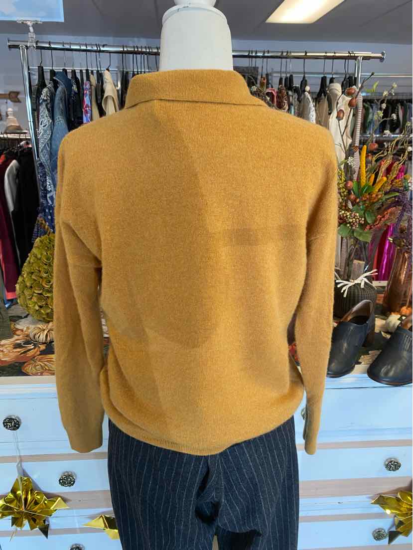 Mustard yellow long-sleeve wool sweater with a high collar and relaxed fit on a mannequin.