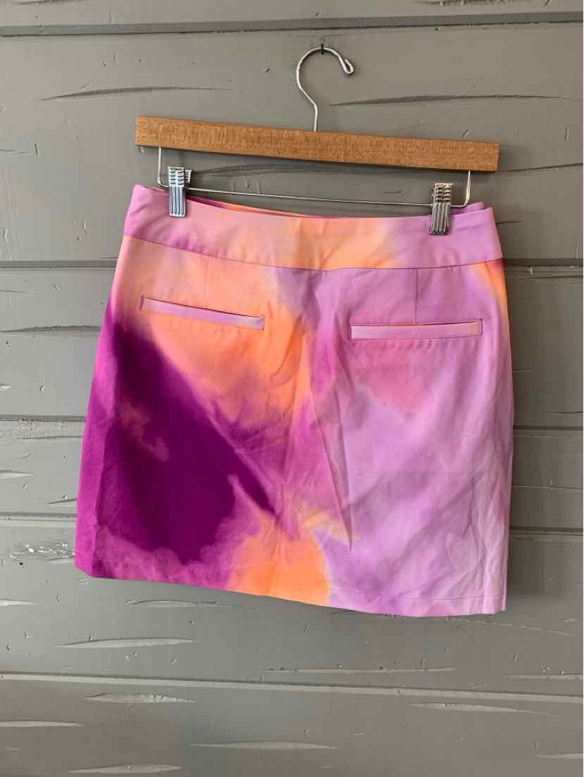 Women's Nike mini skirt in pink, purple, and orange tie-dye with back slit pockets.