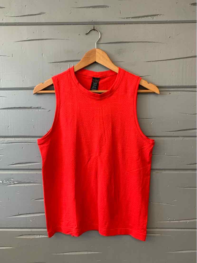 Bright red sleeveless women’s top with a round neckline, displayed on a wooden hanger.