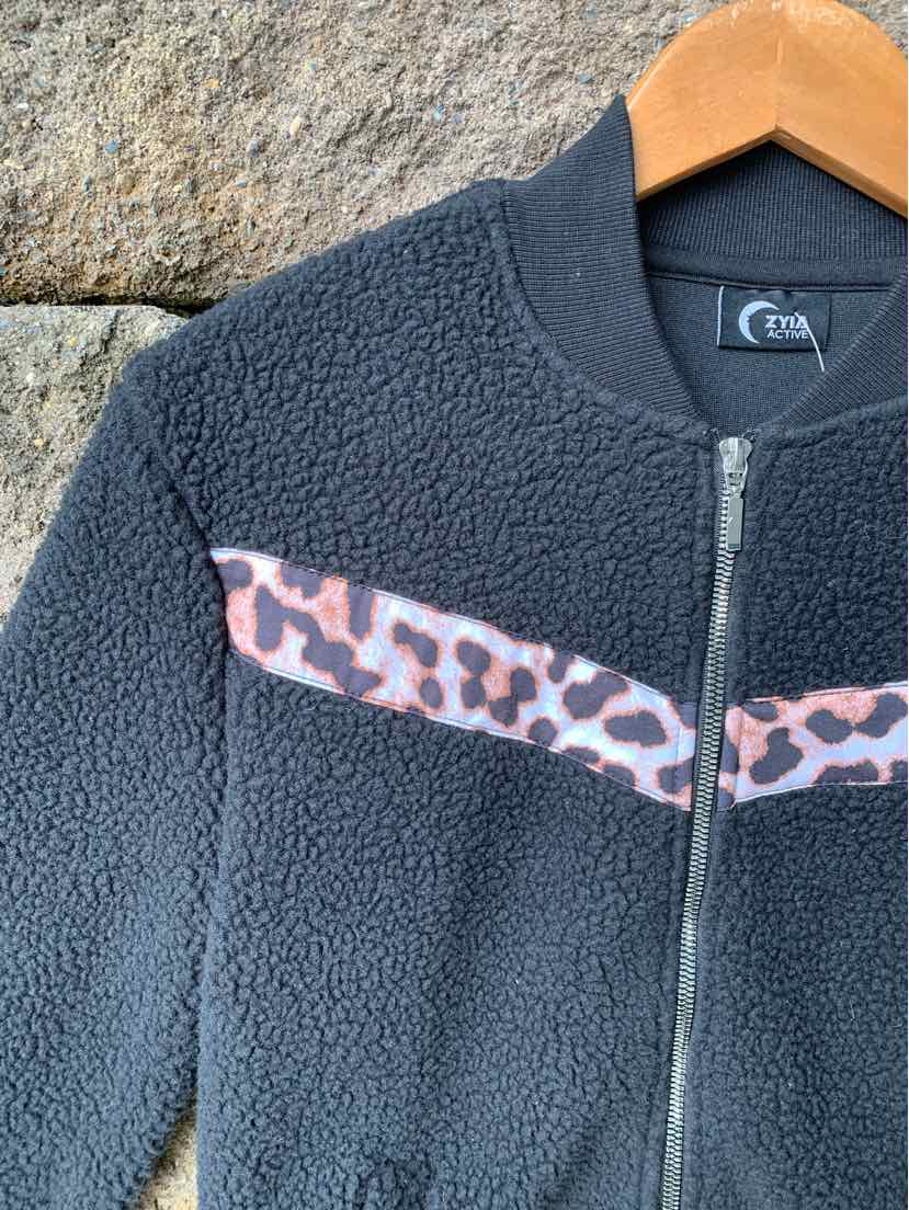 Black fleece jacket with leopard print stripe across chest and zipper front, size XS.