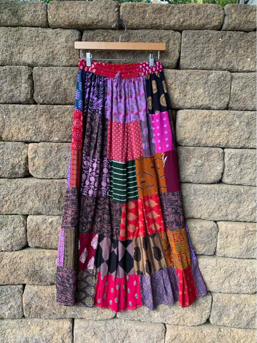 Multicolored bohemian maxi skirt with pleated panels, vibrant geometric patterns, and a gathered waistband.