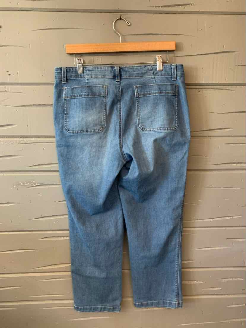 Light blue denim jeans in size 14 with a relaxed fit and back pockets hanging on a wooden hanger against a beige wall.