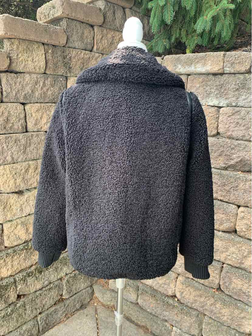 Black fleece jacket with a plush texture, long sleeves, and a folded collar, medium size.