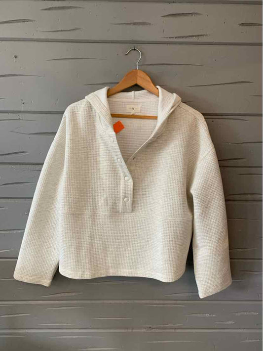 Light gray pullover hoodie with a three-button placket and relaxed fit on a wooden hanger.
