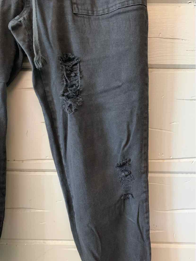 Black distressed denim jeans with ripped detailing and tapered legs in large size.
