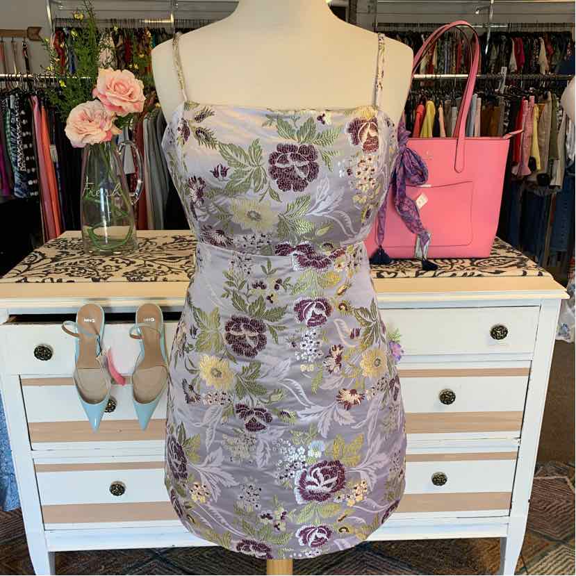 Lavender floral print mini dress with thin spaghetti straps and fitted silhouette.