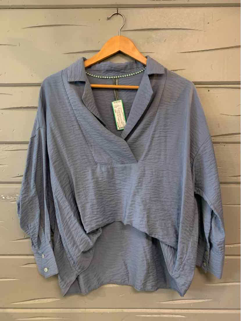 Blue-gray oversized blouse with textured fabric, wide collar, and buttoned cuffs.