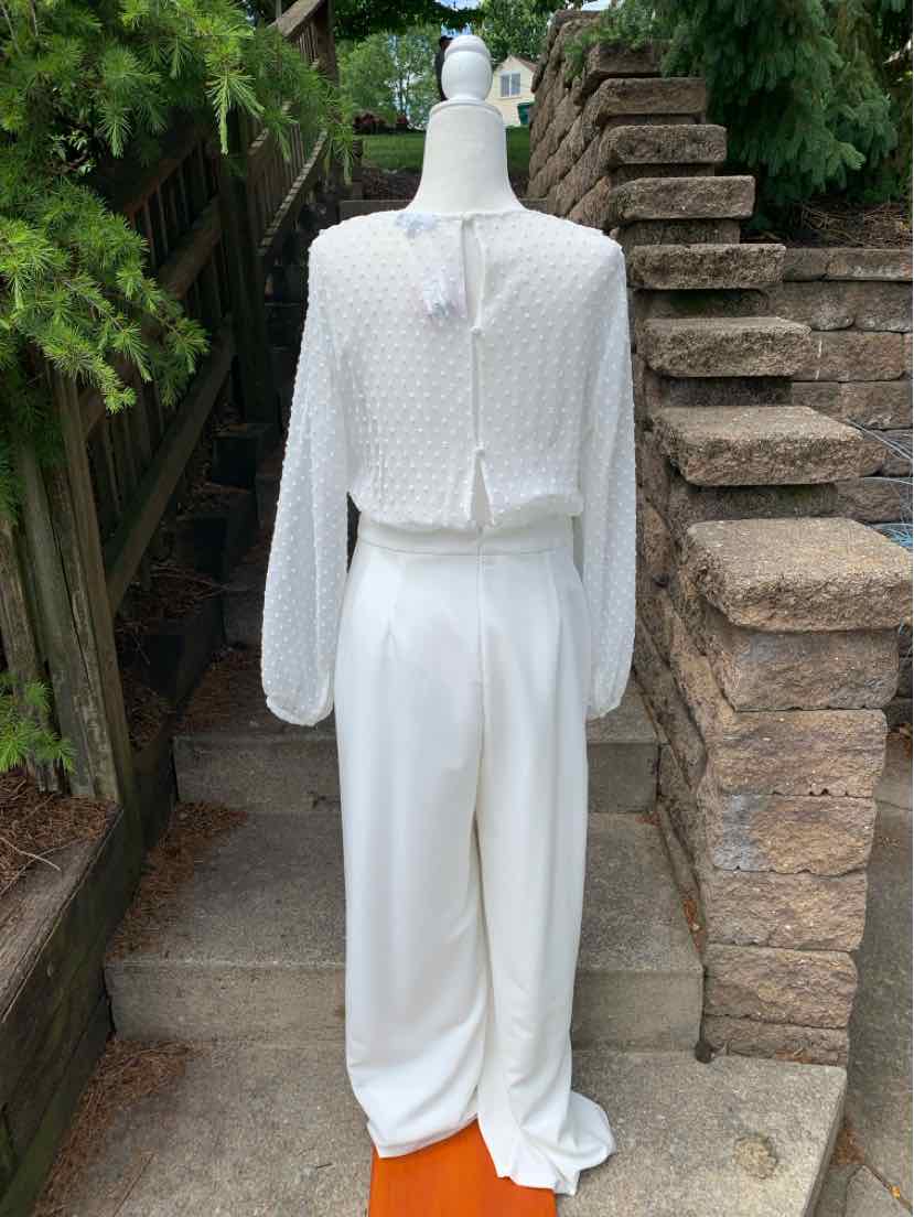 White lace long-sleeve top with keyhole back paired with high-waisted white wide-leg pants.