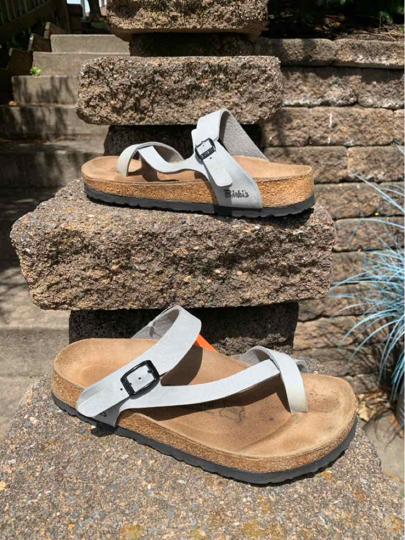 Light gray Birki's sandal with cork footbed, adjustable buckle strap, and toe loop design.