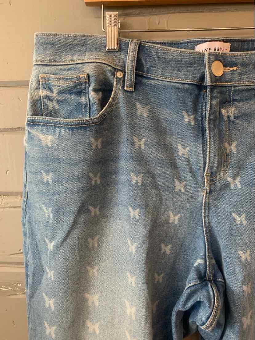 Light blue denim jeans with all-over white butterfly prints, front button and zipper closure, and front pockets.