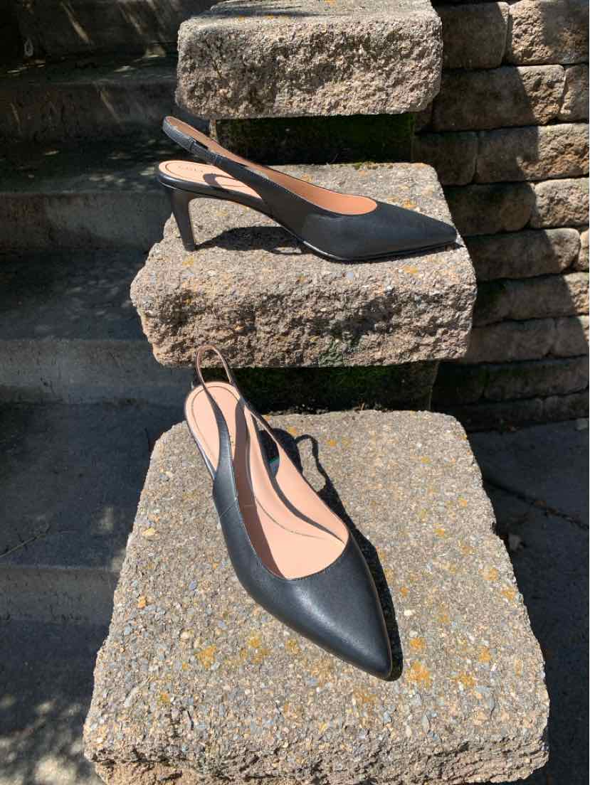 Black leather pointed-toe slingback heels with a low stiletto heel and tan inner lining.