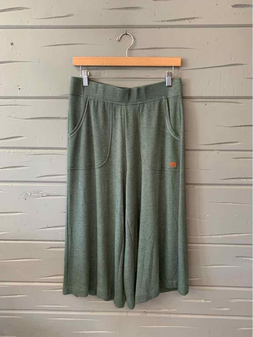 Olive green wide-leg pants with an elastic waistband and side pockets, small orange logo on pocket.
