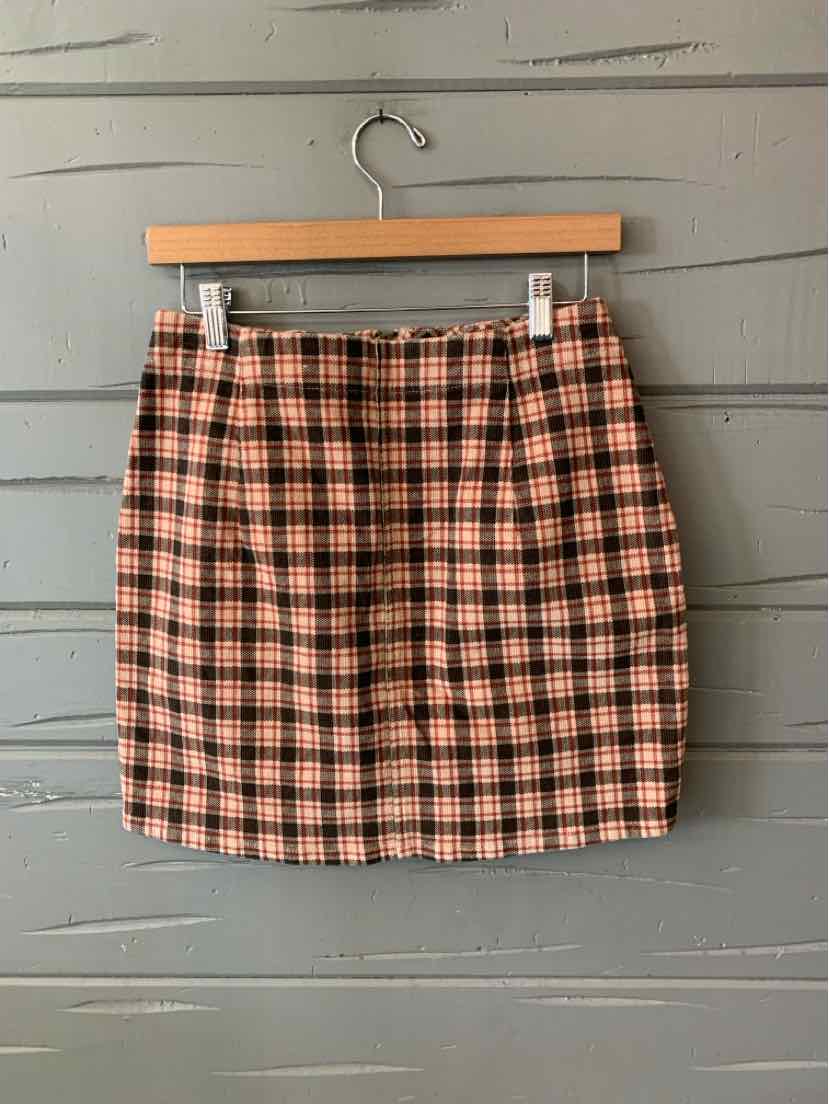 High-waisted mini skirt with orange, black, and cream plaid pattern and a straight silhouette.