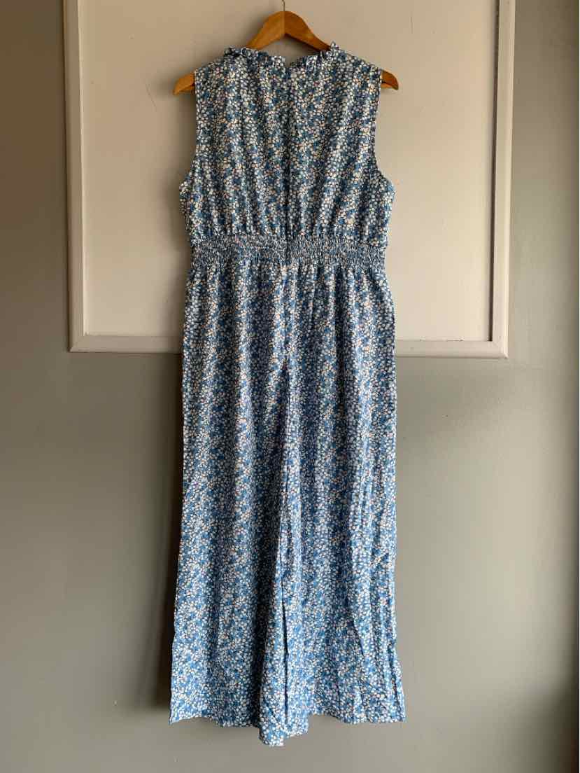 Sleeveless blue and white floral print midi dress with gathered waist and ruffled neckline.