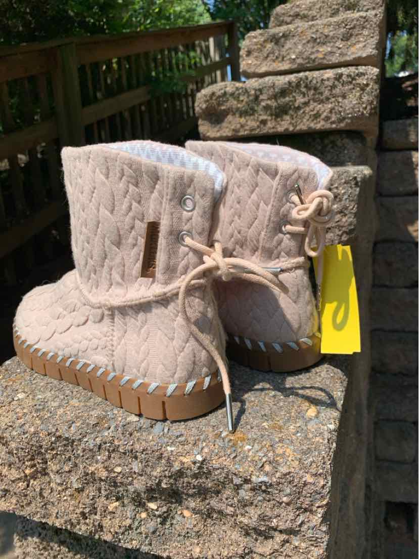 Beige cable knit ankle boots with soft lining and lace-up detail on side, rubber sole.