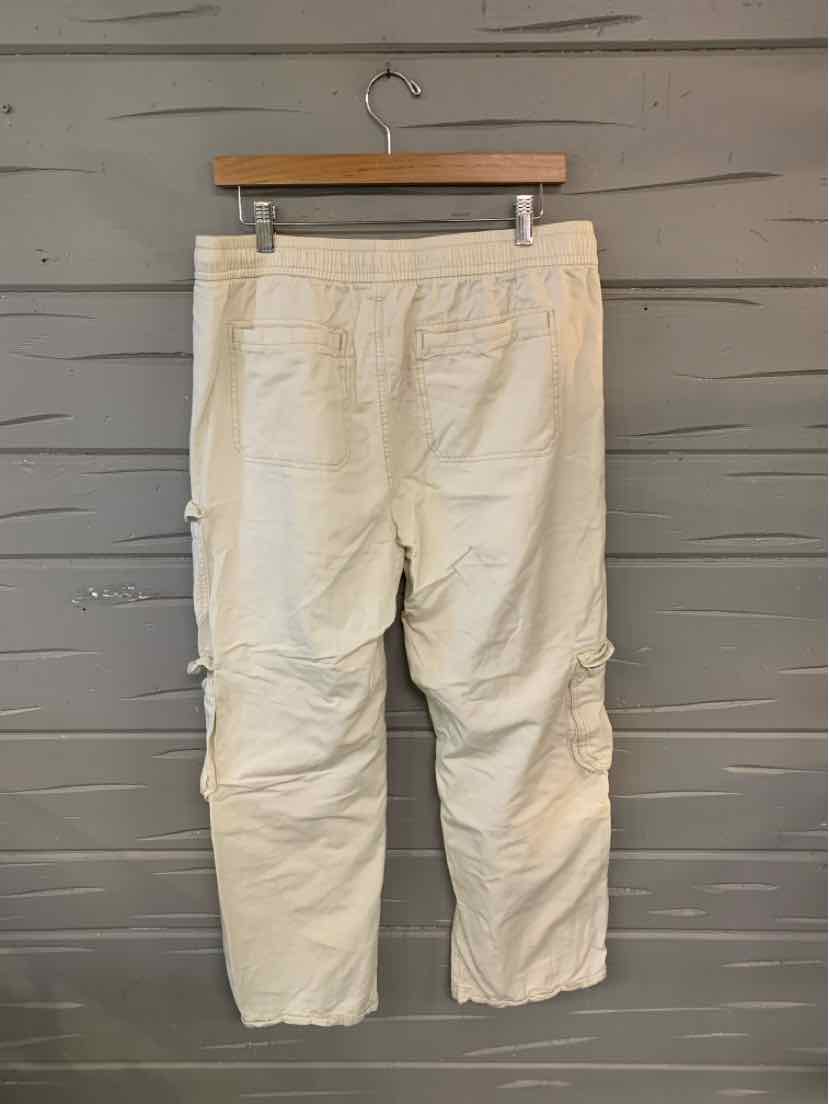 Beige casual pants with back pockets and stitched knee details hanging on wooden hanger.