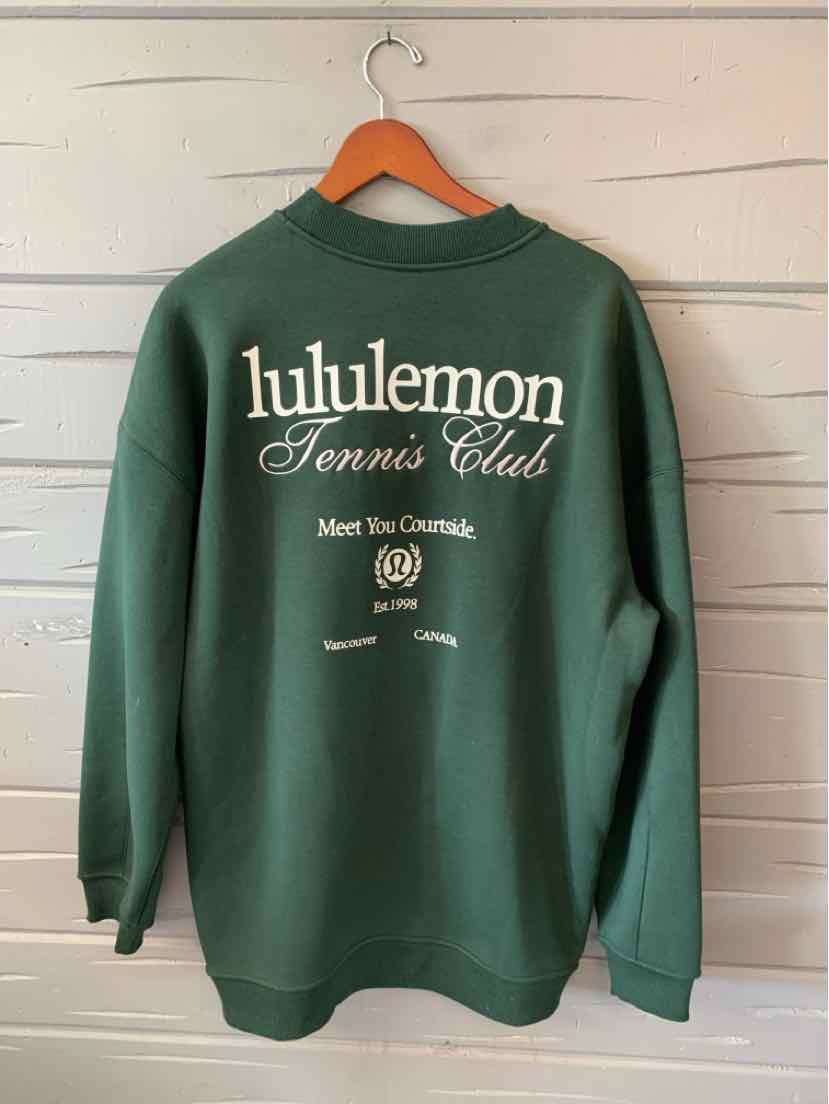 Green long-sleeve sweatshirt with white "lululemon Tennis Club" text and logo on the back.