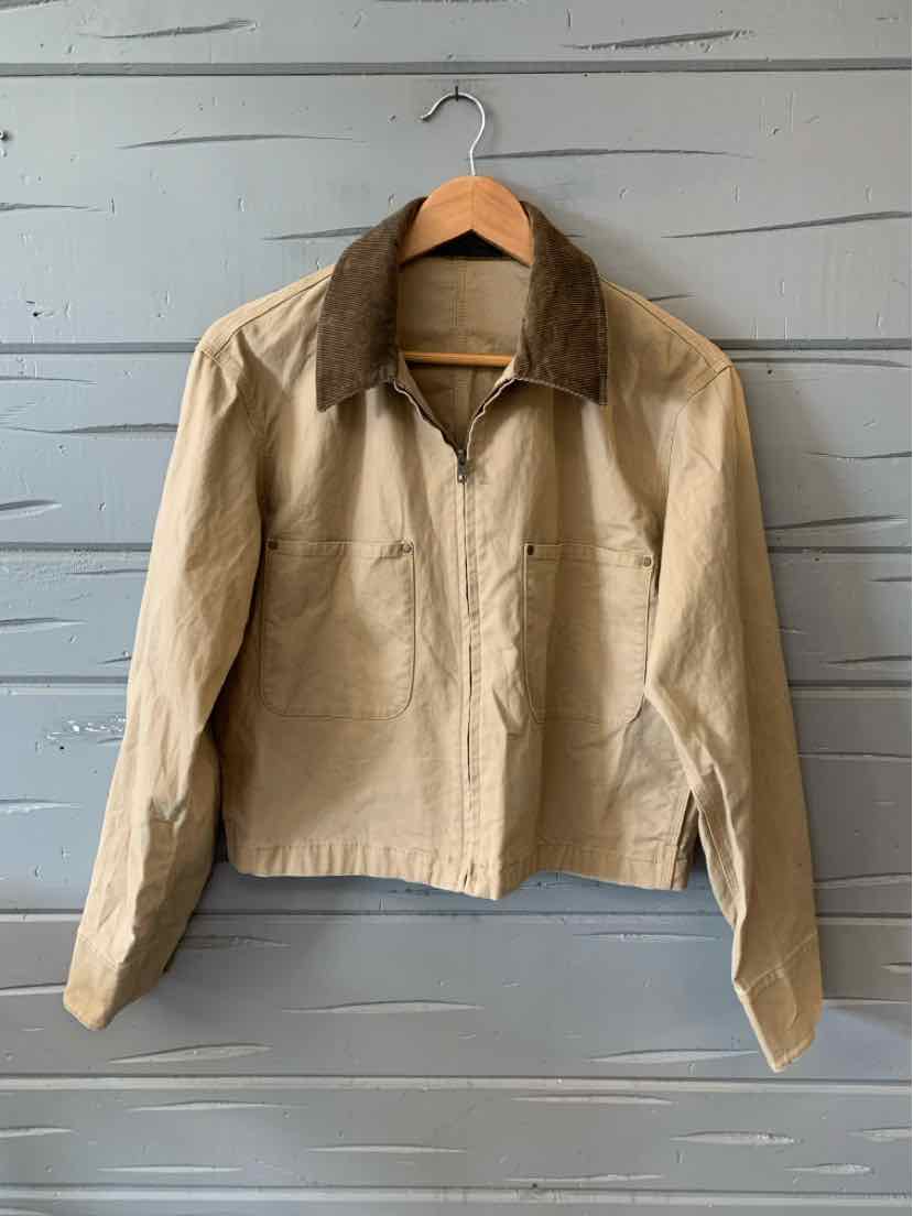 Tan jacket with dark brown corduroy collar and front zipper closure hanging on wooden hanger.