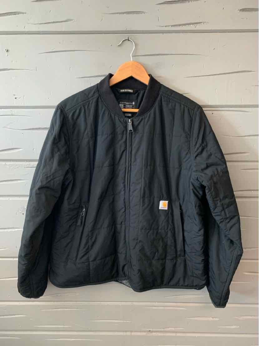 Black quilted Carhartt jacket with ribbed cuffs and collar, front zipper, and logo patch on chest.