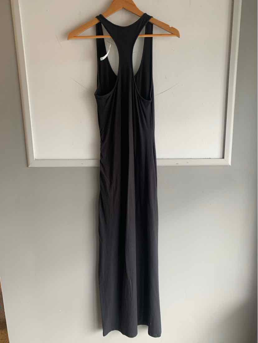 Black sleeveless racerback jumpsuit with wide legs hanging on wooden hanger.
