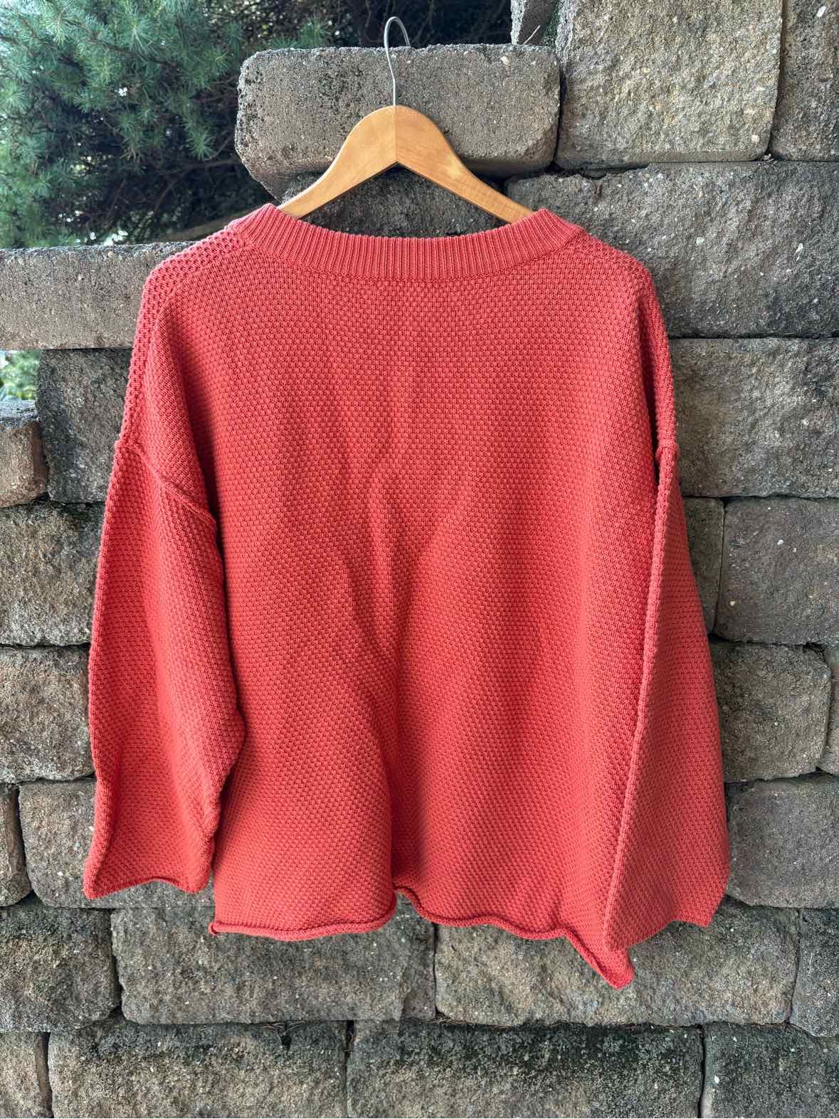 Solid coral-red women’s sweater with a relaxed fit, long sleeves, and a wide neckline.