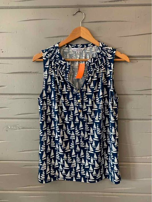 Navy sleeveless blouse with white sailboat pattern and V-neck hanging on wooden hanger.