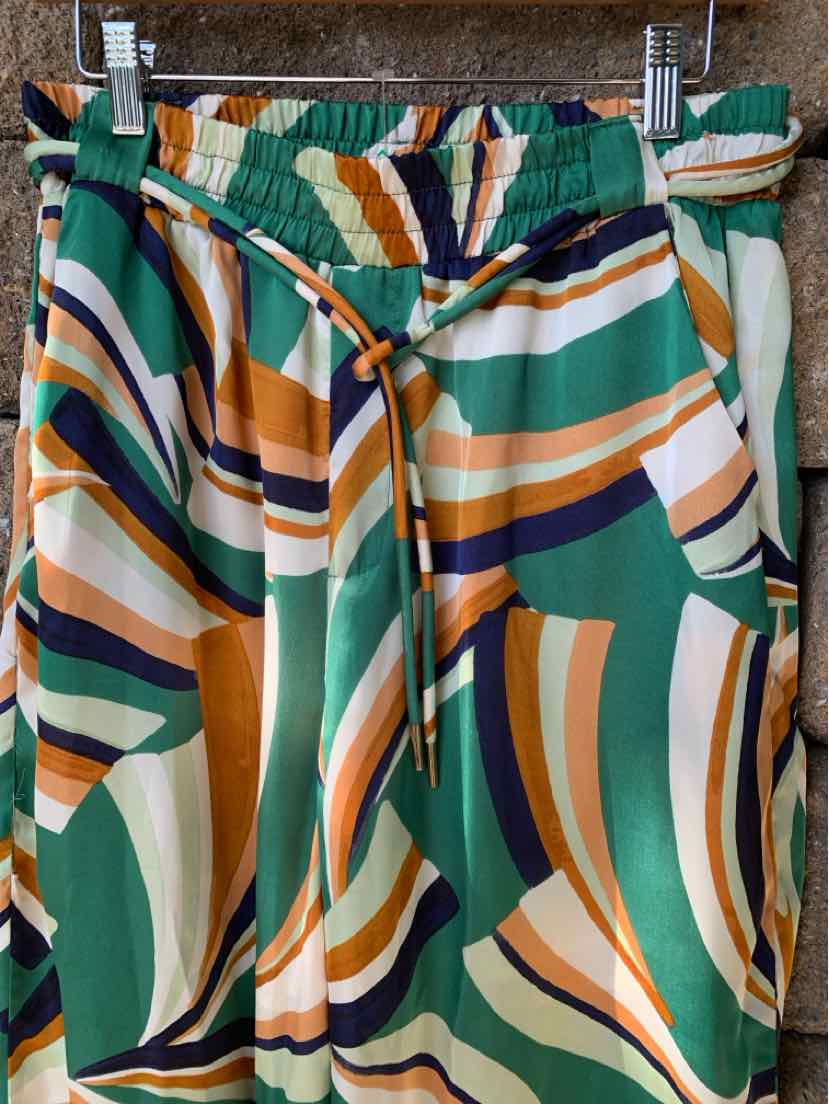 High-waisted pants with abstract green, orange, cream, and navy wavy stripes and a drawstring waist.