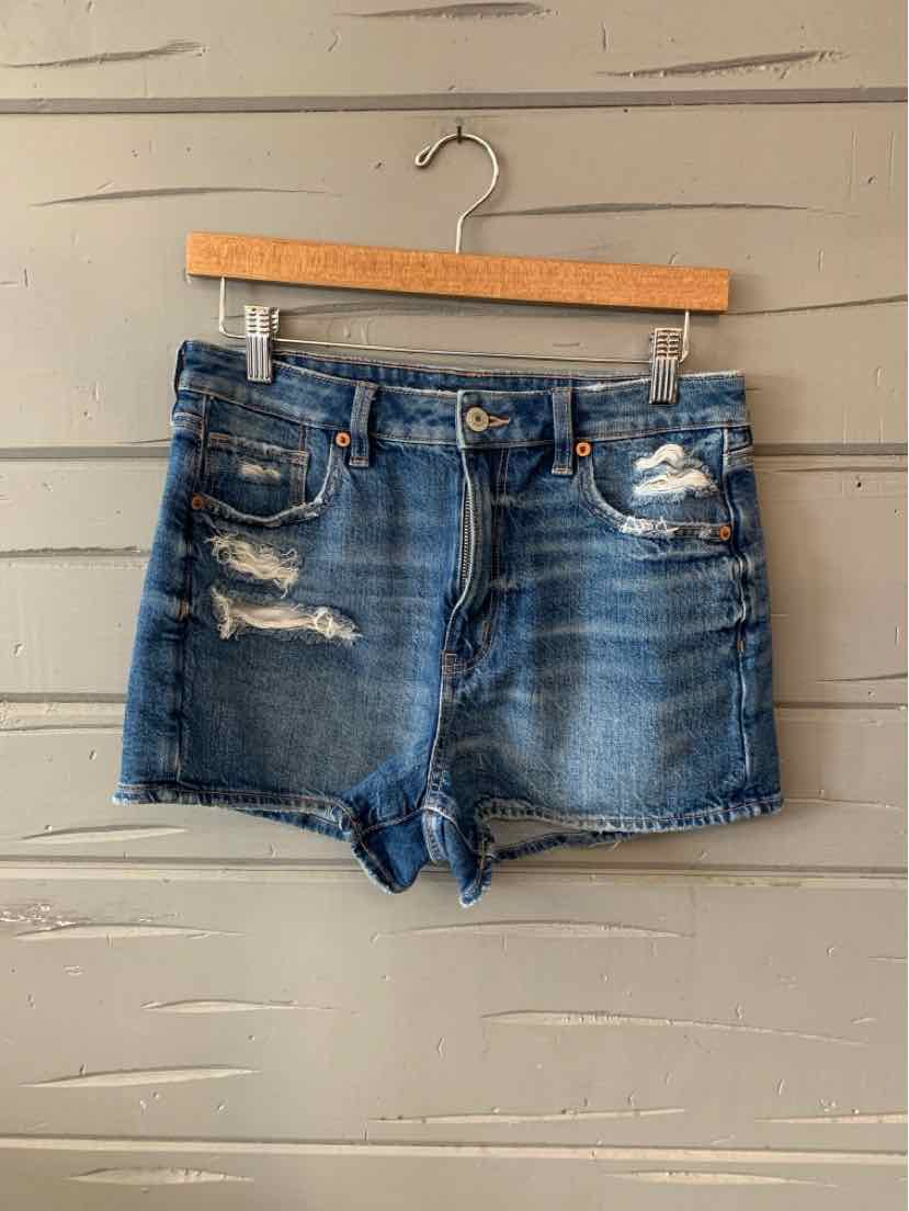 Blue denim shorts with distressed details, five-pocket design, and frayed hems.