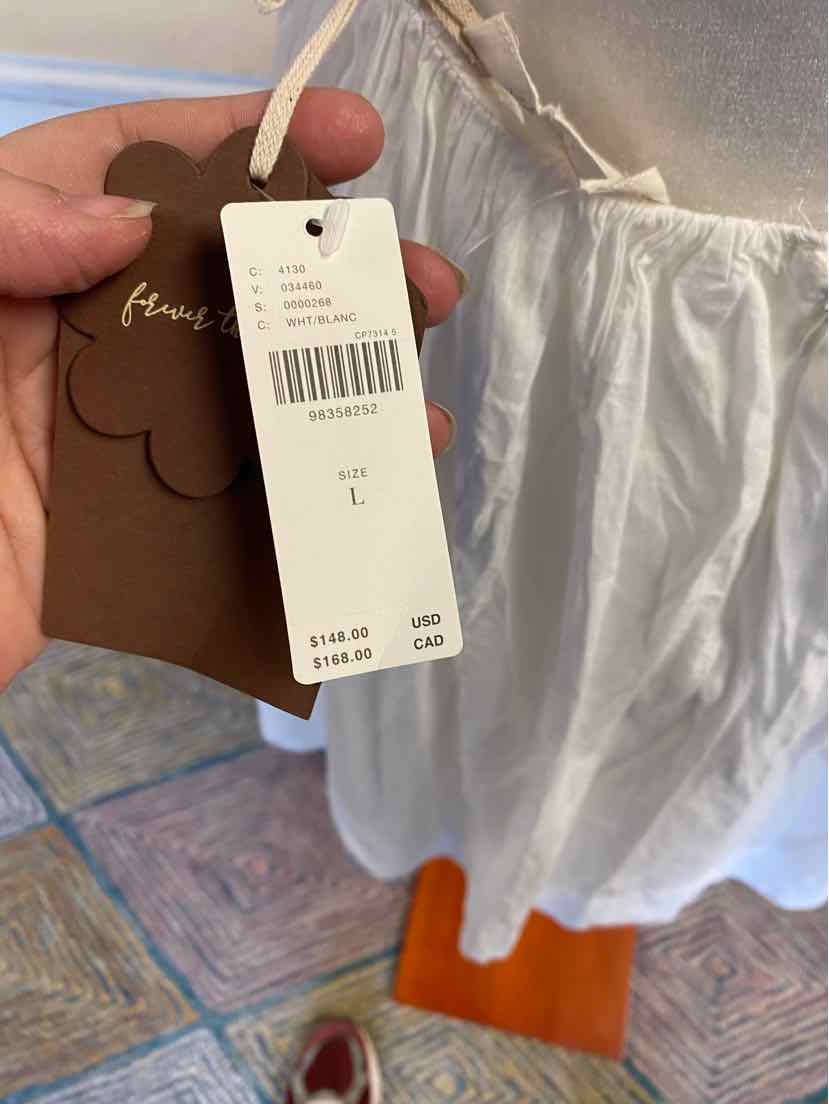White Anthropologie skirt with gathered waist and size tag hanging from waistband.