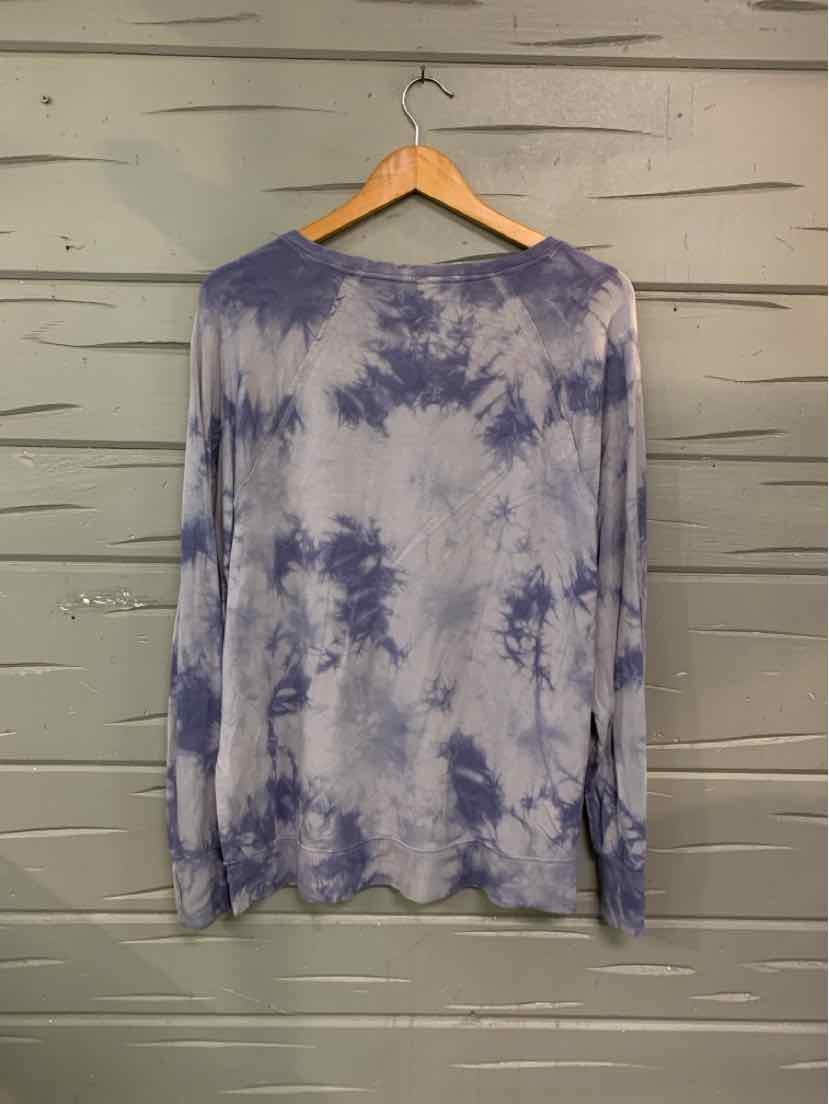 Long-sleeve tie-dye shirt in soft blue and white with a relaxed fit hanging on wooden hanger.