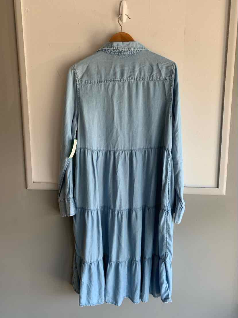 Light blue tiered long-sleeve dress with buttoned cuffs and a loose fit hanging on a wooden hanger.