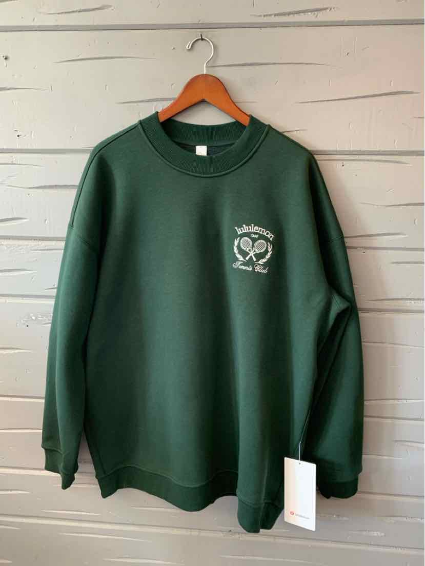 Dark green oversized crewneck sweatshirt with small white Lululemon logo on left chest, ribbed cuffs and hem.