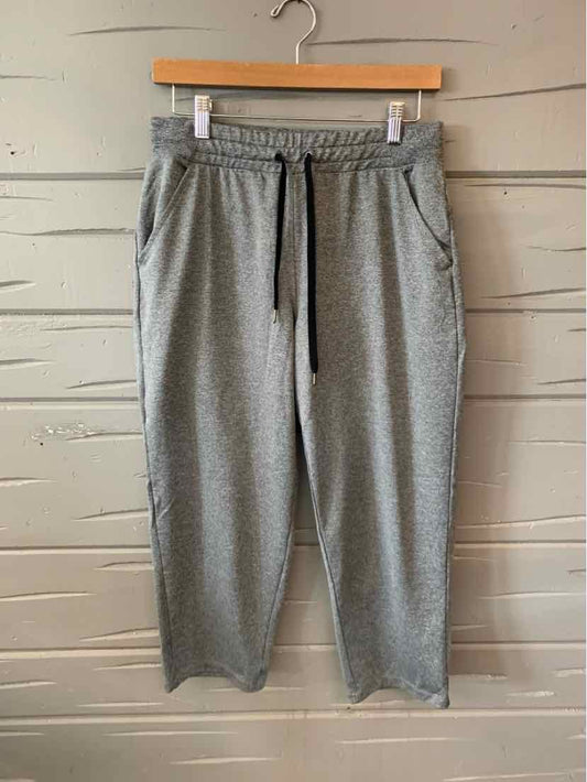 Gray mid-rise jogger pants with elastic waistband and black drawstring, tapered legs, and side pockets.