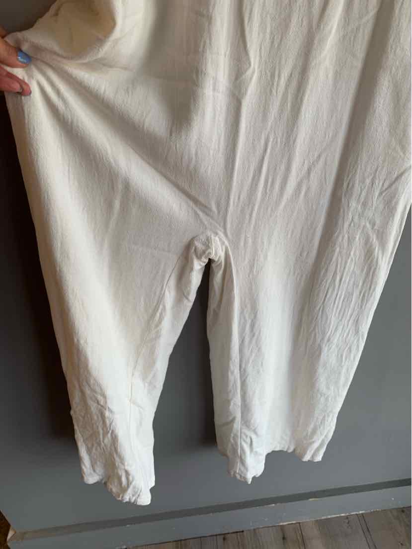 Off-white loose-fit pants with an elastic waistband and tapered legs in medium size.