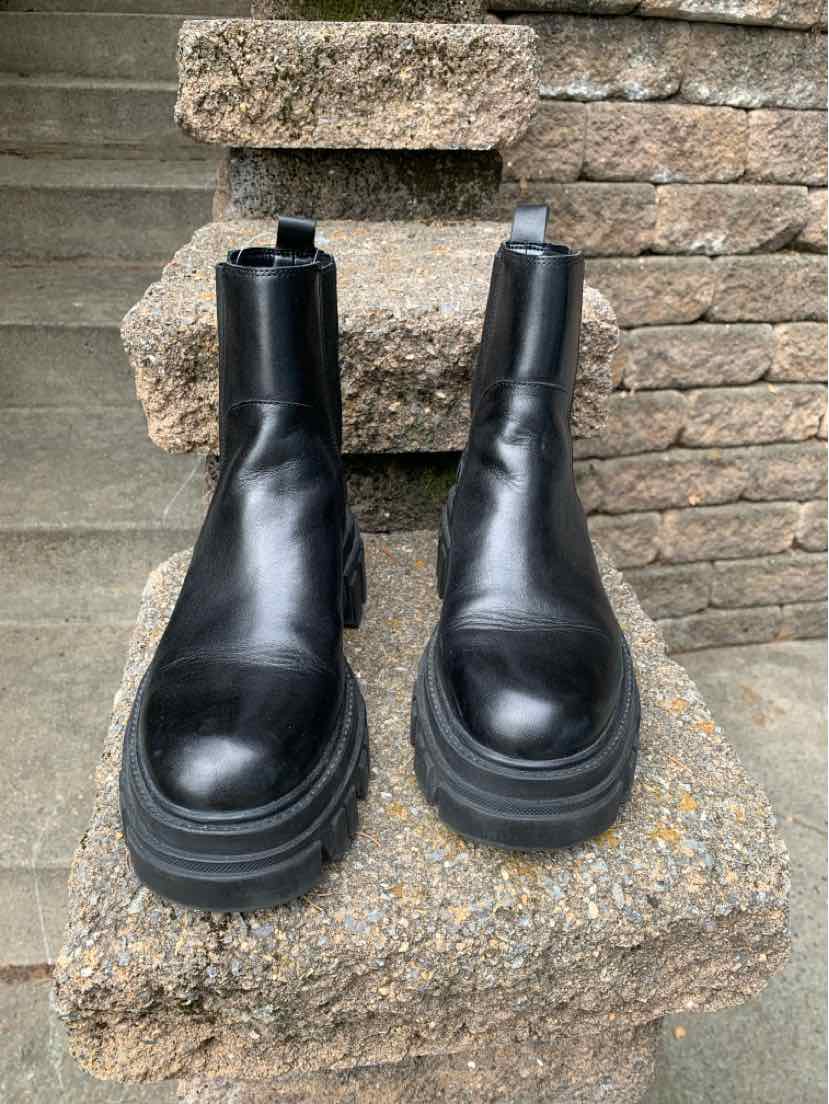 Black leather ankle boots with chunky lug soles and elastic side panels, size 6.5.