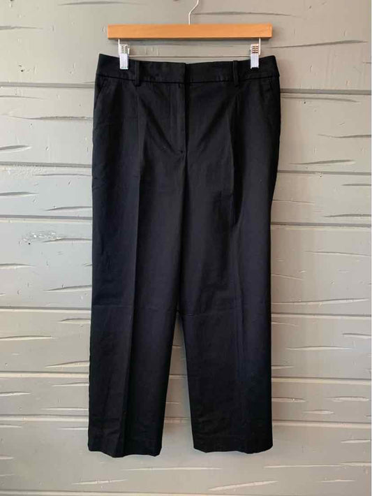 Black tailored dress pants with front pockets and belt loops, size 8P, hanging on wooden hanger.