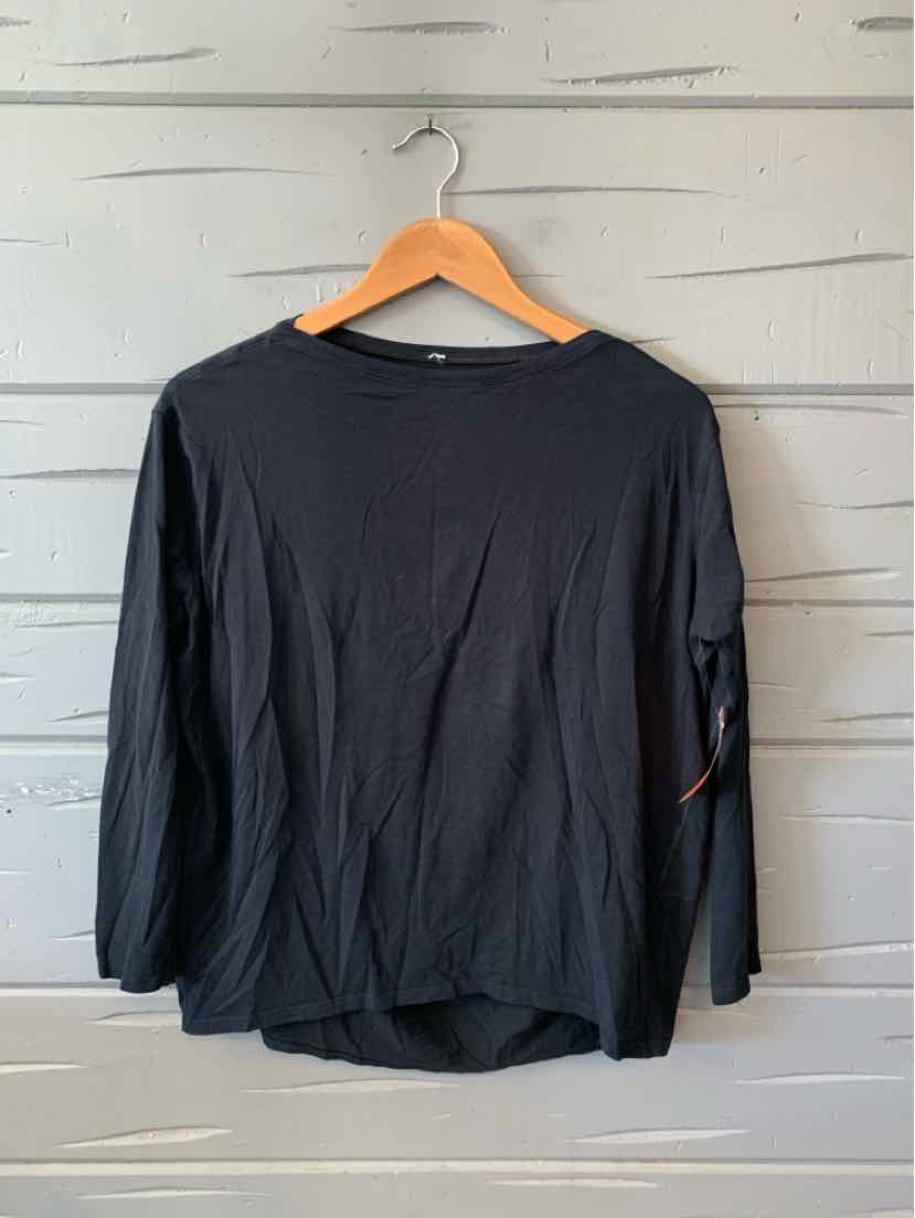 Black long-sleeve athletic top with crew neck and relaxed fit hanging on wooden hanger.