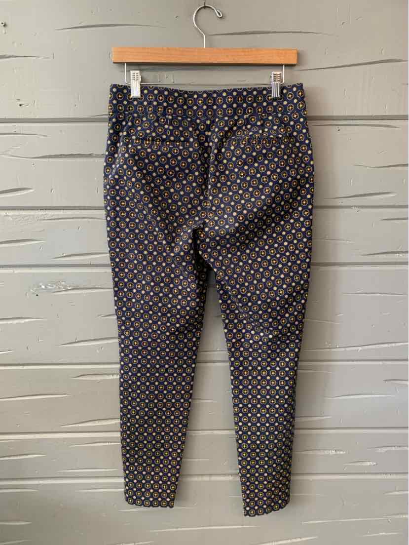 Slim-fit pants with a multicolored geometric pattern on a dark background, tailored with back welt pockets and belt loops.