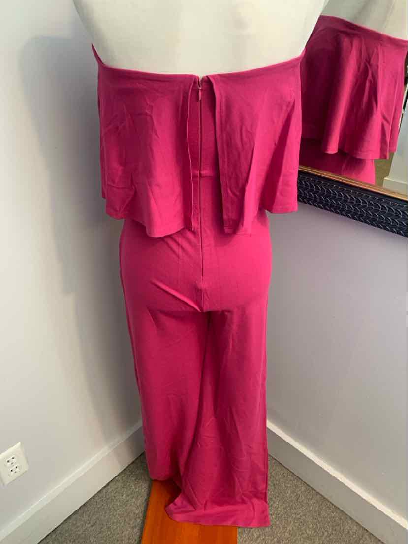 Pink off-shoulder jumpsuit with flounce bodice and wide-leg pants on mannequin.