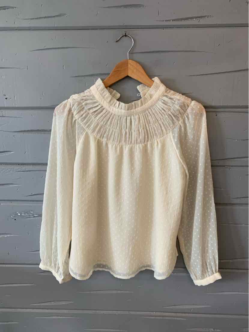 Cream long-sleeve blouse with sheer dotted fabric and smocked high neckline and cuffs.