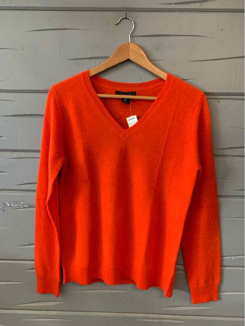 Bright orange V-neck cashmere sweater with long sleeves, medium size, on wooden hanger.